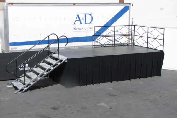Staging with safety railings, skirting, & steel deck step unit