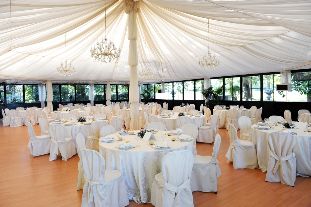 Wedding venue under a marquee with ceiling drape around a center pole